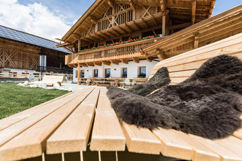 Bauernhof Südtirol mit gemütlichen Holzliegen im großen Garten